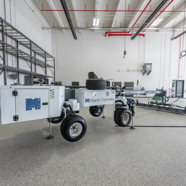 Concrete leveling machine by Martin Concrete operating at night with mist and lights in background