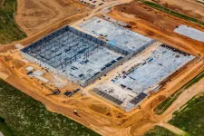 Thumbnail for Aerial view of a large industrial construction site with steel framework and concrete foundations under development.