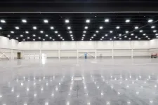 Thumbnail for Spacious empty industrial hall with high ceiling and bright overhead lights reflecting on polished concrete floor
