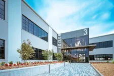Thumbnail for Modern office building with Edison 3 signage, large windows, landscaped entrance, and blue sky background.