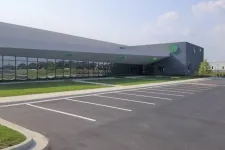 Thumbnail for Modern commercial building with large windows and empty parking lot on a clear sunny day