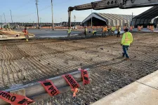 Thumbnail for Construction workers in safety vests preparing a reinforced concrete foundation with rebar and pouring concrete onsite.