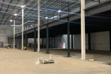 Thumbnail for Large industrial warehouse under construction with steel framework and workers installing mezzanine level