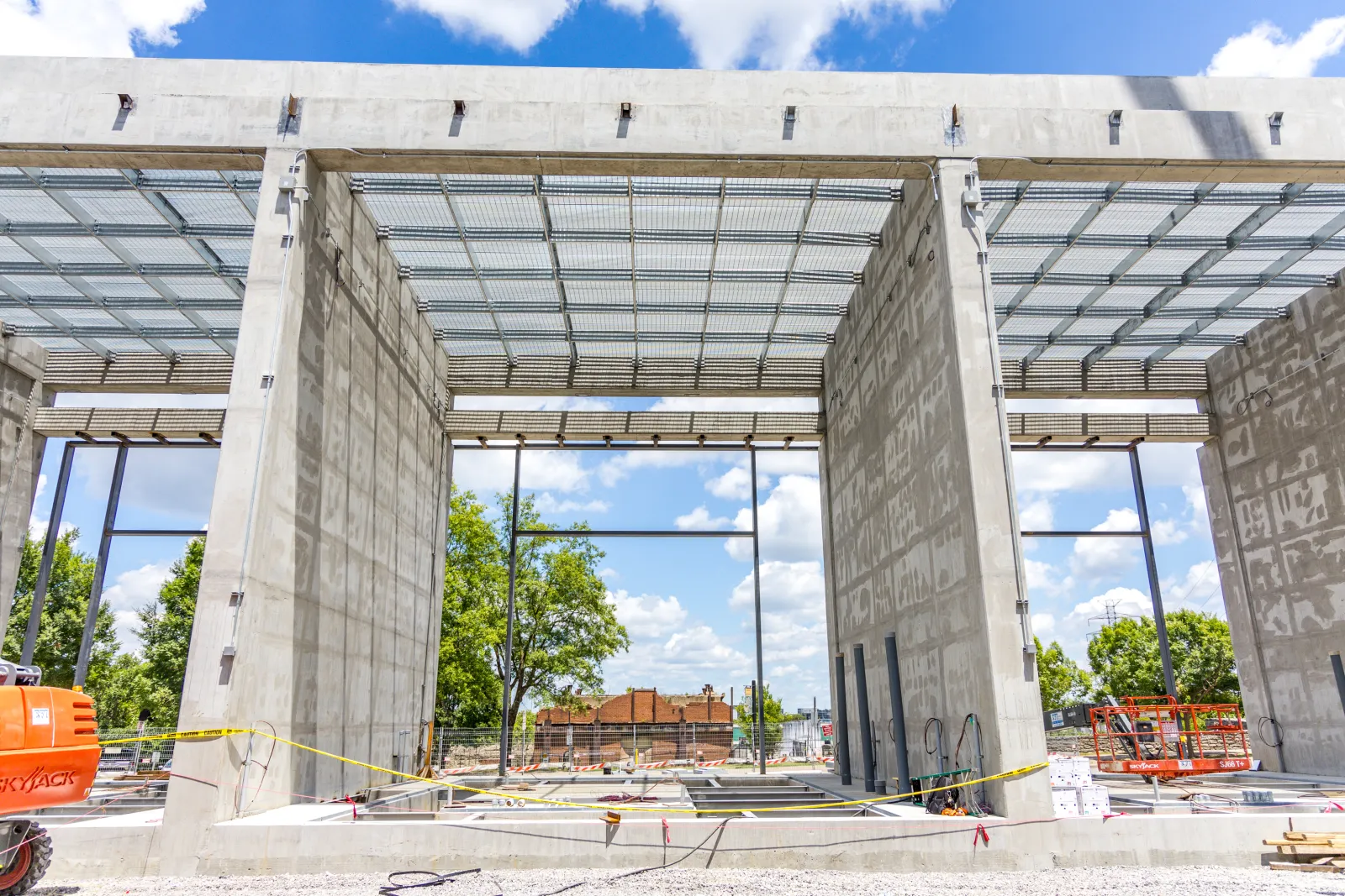 Concrete structure of a building under construction with exposed steel framework and blue sky background